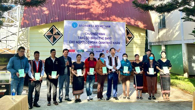 Đại diện Bảo hiểm xã hội Việt Nam trao tặng sổ bảo hiểm xã hội, thẻ bảo hiểm y tế cho người dân khó khăn ở làng Ia Nueng, xã Biển Hồ, thành phố Pleiku, tháng 12/2022 (Ảnh: Hà Ly)