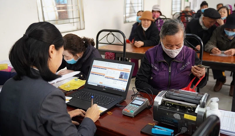 Chi trả lương hưu và trợ cấp bảo hiểm xã hội hằng tháng cho người dân tại phường Xuân Đỉnh, Hà Nội. (Ảnh: VNPost)