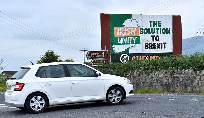 Một chiếc ô-tô lái qua một tấm biển về Brexit tại Ravensdale, Bắc Ireland, ngày 21/6/2022. (Ảnh: REUTERS)