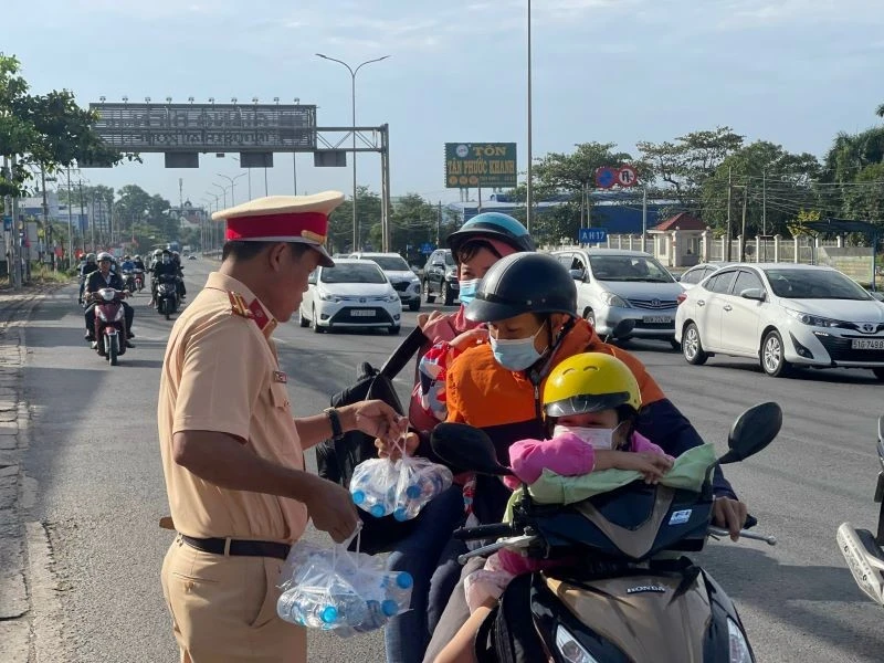 Lực lượng Cảnh sát giao thông phát nước giúp người tham giao thông trên đường về quê đón Tết Nguyên đán 2023. 