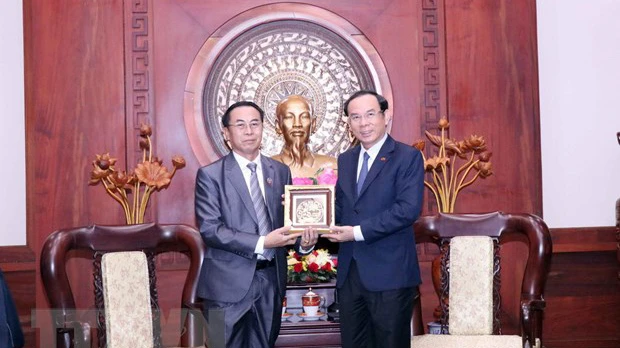 Bí thư Thành ủy Thành phố Hồ Chí Minh Nguyễn Văn Nên trao tặng phẩm lưu niệm cho ông Khampheng Vilaphanh. (Ảnh: TTXVN)