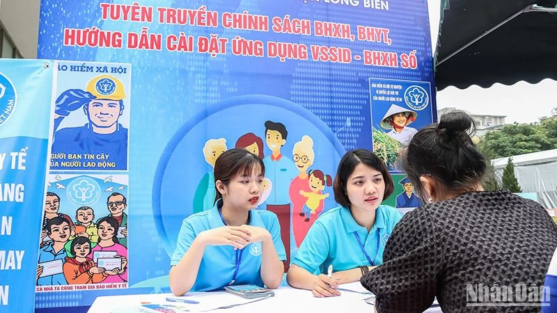 Cán bộ Bảo hiểm xã hội quận Long Biên, Hà Nội tư vấn về chính sách với người dân. (Ảnh: Nam Nguyễn)