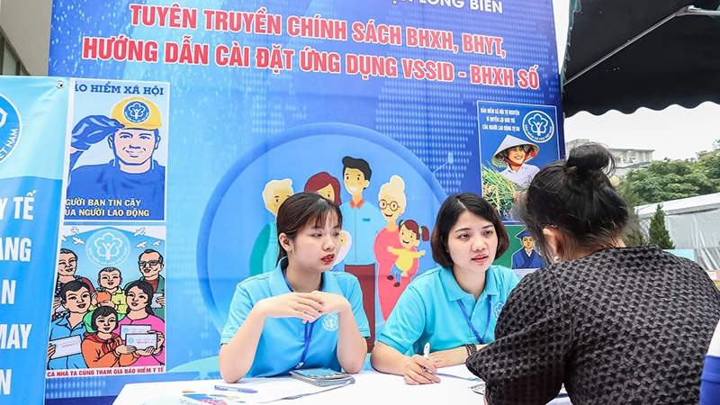 Cán bộ Bảo hiểm xã hội quận Long Biên, Hà Nội giới thiệu chính sách với người lao động. (Ảnh: Ngân Anh)