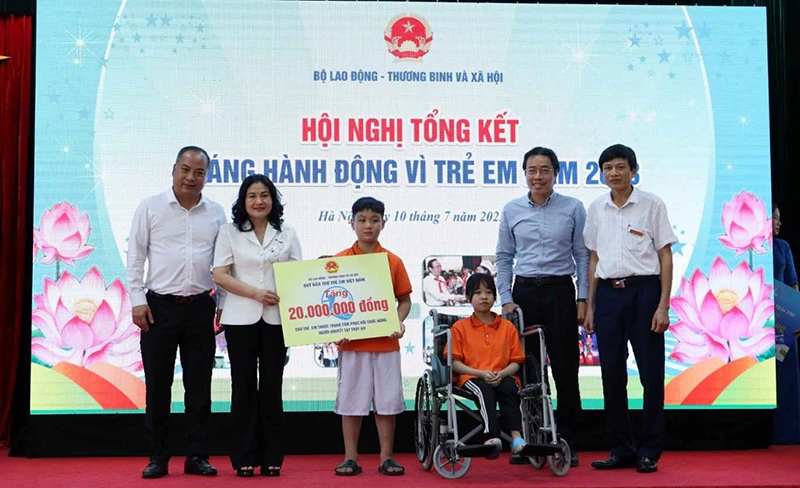 Thứ trưởng Nguyễn Thị Hà tặng quà cho trẻ em tại Trung tâm Phục hồi chức năng người khuyết tật Thụy An. (Ảnh: Molisa) 