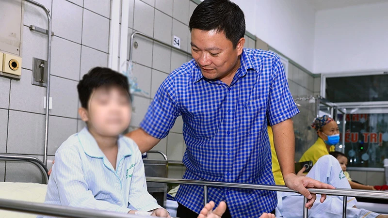 Đại diện Cục Bảo trợ xã hội thăm, động viên bệnh nhi là nạn nhân trong vụ cháy chung cư mini tại Khương Hạ đang điều trị tại Bệnh viện Bạch Mai. (Ảnh: Molisa)