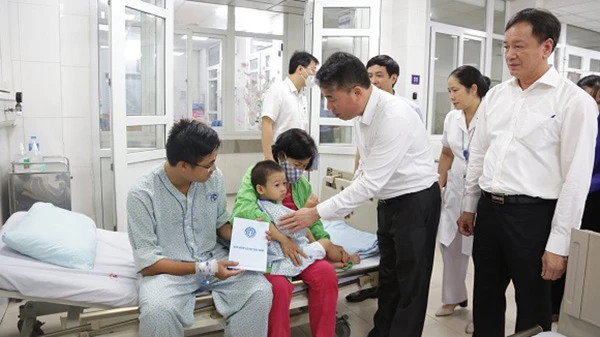 Tổng Giám đốc Bảo hiểm xã hội Việt Nam Nguyễn Thế Mạnh thăm hỏi, trao hỗ trợ người bị thương trong vụ cháy chung cư mini tại Khương Hạ, quận Thanh Xuân, Hà Nội. (Ảnh: Tâm Trung)