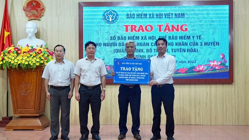 Tổng Giám đốc Bảo hiểm xã hội Việt Nam Nguyễn Thế Mạnh trao tặng sổ bảo hiểm xã hội, thẻ bảo hiểm y tế cho các địa phương của tỉnh Quảng Bình, tháng 7/2023. (Ảnh: TÂM TRUNG)