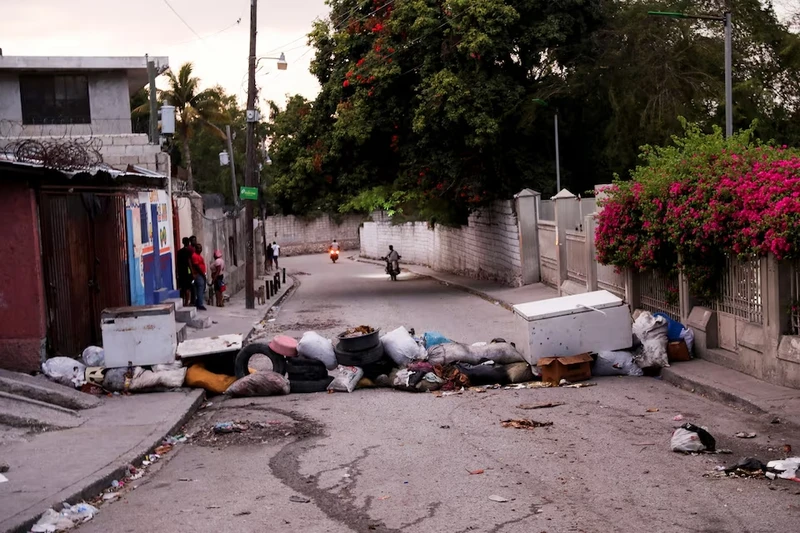 Người dân đứng trên một con phố có rào chắn trong bối cảnh bạo lực băng đảng leo thang ở thủ đô Port-au-Prince, Haiti ngày 20/3/2024. (Ảnh: Reuters)