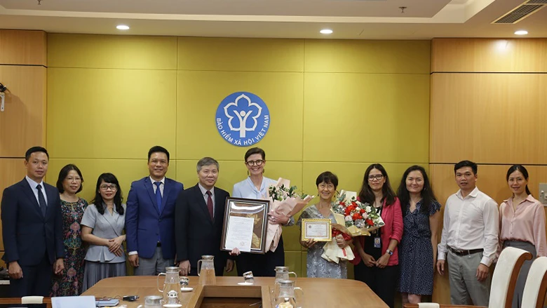Trao Kỷ niệm chương “Vì sự nghiệp bảo hiểm xã hội Việt Nam” tới Tiến sĩ Annie Chu và tặng hoa Đoàn công tác của WHO tại Việt Nam. (Ảnh: VSS)