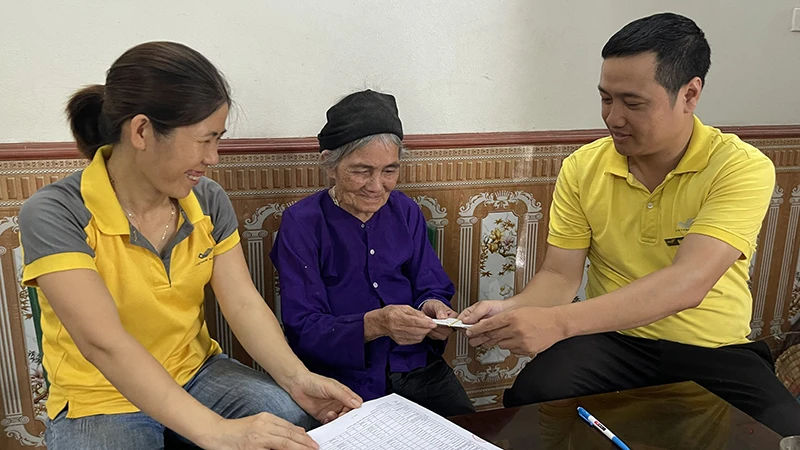 Bà Chu Thị Hỵ, xã Sàn Viên, huyện Lộc Bình, tỉnh Lạng Sơn, được nhân viên bưu điện chi trả tiền trợ cấp tuất tại nhà. (Ảnh: Vietnam Post)