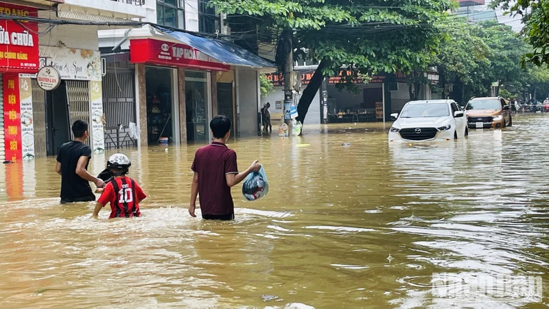 Người dân chạy lũ tại đường Thành Công, phường Nguyễn Thái Học, thành phố Yên Bái. (Ảnh: THANH SƠN)