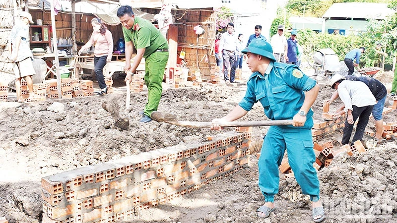 Lực lượng vũ trang cùng các đoàn thể chính trị xã Huyền Hội, huyện Càng Long, tỉnh Trà Vinh, hỗ trợ người dân xây nhà. (Ảnh: KHỞI - GIANG)