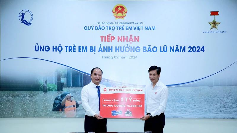 Giám đốc Quỹ Bảo trợ trẻ em Việt Nam Đinh Tiến Hải tiếp nhận tượng trưng số tiền 1 tỷ đồng sản phẩm váng sữa và phô-mai từ Phó Tổng giám đốc Zott Việt Nam Bùi Quốc Hùng. (Ảnh: NFVC)