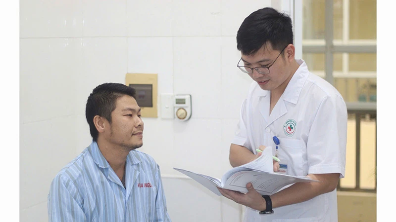 Bác sĩ Bệnh viện đa khoa Phúc Thọ, thành phố Hà Nội tư vấn cho người bệnh chế độ luyện tập thể thao nhằm hạn chế chấn thương. (Ảnh TRUNG THIỆN) 