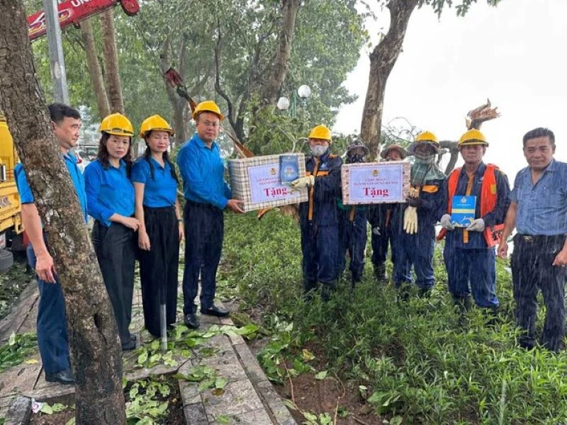  Chủ tịch Liên đoàn Lao động thành phố Hà Nội Phạm Quang Thanh và Chủ tịch Công đoàn ngành Xây dựng Hà Nội Nguyễn Thị Thanh, tặng quà công nhân Công ty TNHH MTV Thoát nước Hà Nội đang dọn cây đổ bên bờ Hồ Tây.