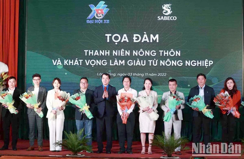 Ban Tổ chức tặng hoa cho các đại biểu, thanh niên nhận giải thưởng Lương Định Của điển hình qua các thời kỳ tham gia tọa đàm.