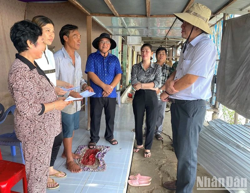 Bí thư Huyện ủy Năm Căn (tỉnh Cà Mau) Dư Minh Hùng (bìa phải) thăm hỏi, động viên các hộ dân có nhà bị sạt lở ở xã Tam Giang. 