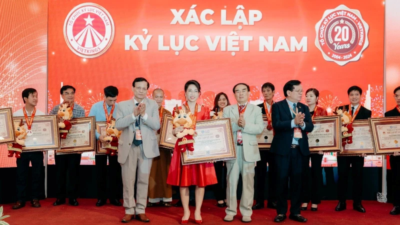 Đại diện Sconnect (váy đỏ) nhận hai chứng nhận kỷ lục Việt Nam. (Ảnh: Bảo Châu)