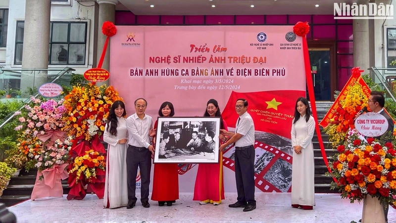 Đạo diễn Triệu Tuấn (người cầm ảnh bên phải) đại diện gia đình cố Nghệ sĩ nhiếp ảnh Triệu Đại trao tặng bộ ảnh cho Bảo tàng Phụ nữ Việt Nam.