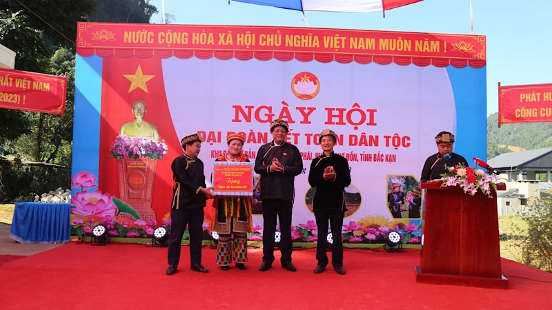 Phó Chủ tịch Quốc hội Trần Quang Phương tặng quà cho nhân dân Bản Cuôn. (Ảnh: CÔNG LUẬN).
