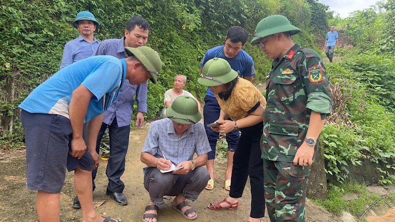 Lực lượng chức năng kiểm tra, xác định mức độ nguy cơ sạt lở tại thôn Nà Pha. (Ảnh: NGỌC HÂN).