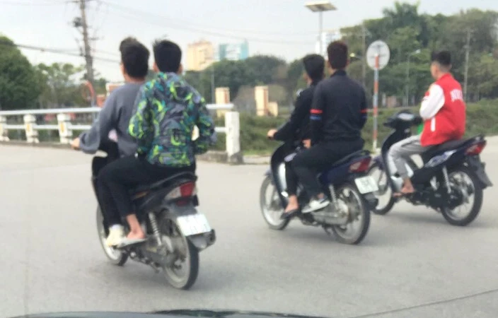 Các thanh niên không đội mũ bảo hiểm khi điều khiển phương tiện tham gia giao thông.