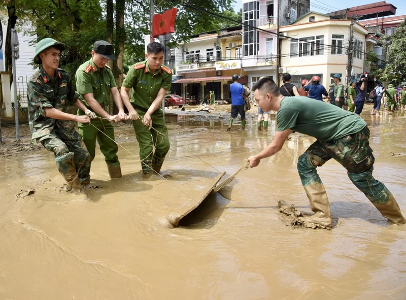 Các lực lượng quân đội và công an giúp nhân dân dọn dẹp vệ sinh môi trường sau bão lũ tại thành phố Yên Bái (Ảnh: TRẦN HẢI). 