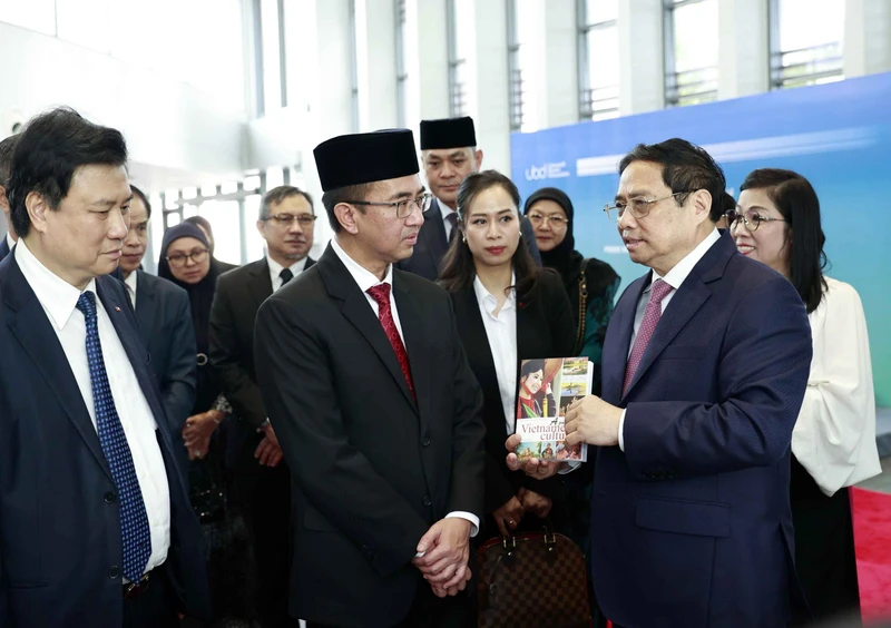 Thủ tướng Phạm Minh Chính xem trưng bày sách tiếng Việt tại Trường đại học Quốc gia Brunei. (Ảnh TTXVN)