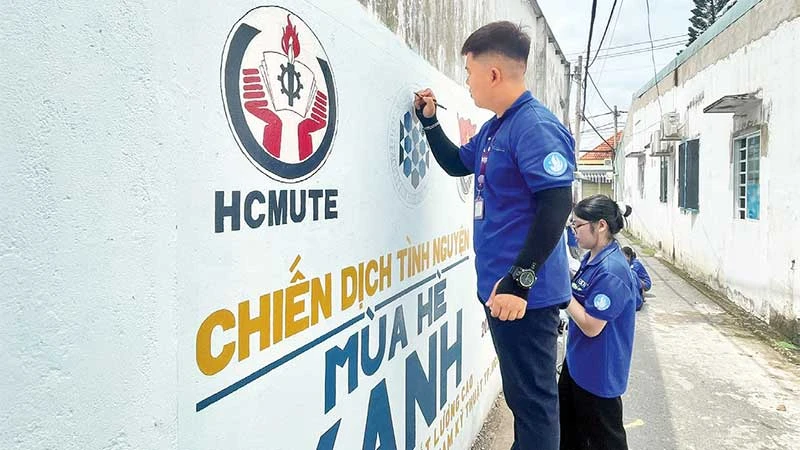 Các chiến sĩ Mùa hè xanh sơn sửa và vẽ tranh cổ động trên bức tường ở Khu phố 4, phường Tăng Nhơn Phú.