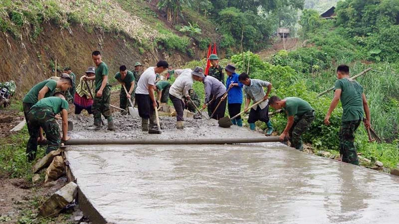 Cán bộ, chiến sĩ Trung đoàn 254, Bộ Chỉ huy quân sự tỉnh Lào Cai cùng người dân địa phương đổ bê-tông đường giao thông liên thôn ở xã Nậm Chạc, huyện Bát Xát, tỉnh Lào Cai.