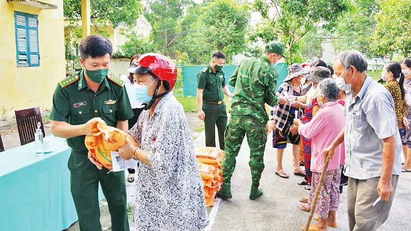 Các chiến sĩ Đồn Biên phòng Nhơn Hưng tặng gạo cho người nghèo.