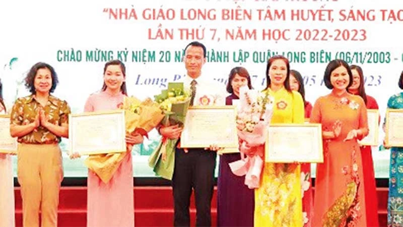 Thầy giáo Đặng Vũ Hiệp (người đứng giữa) nhận giải thưởng “Nhà giáo Long Biên tâm huyết, sáng tạo lần thứ 7, năm học 2022-2023”.