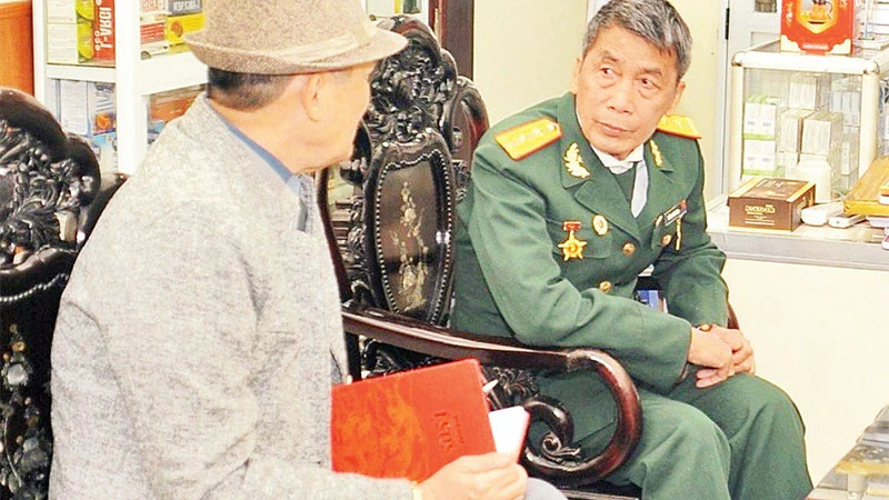 Trung úy Ngô Văn Chiến, Chủ tịch Hội cựu doanh nghiệp, doanh nhân cựu chiến binh huyện Yên Phong (người mặc quân phục) chuyện trò cùng tác giả.