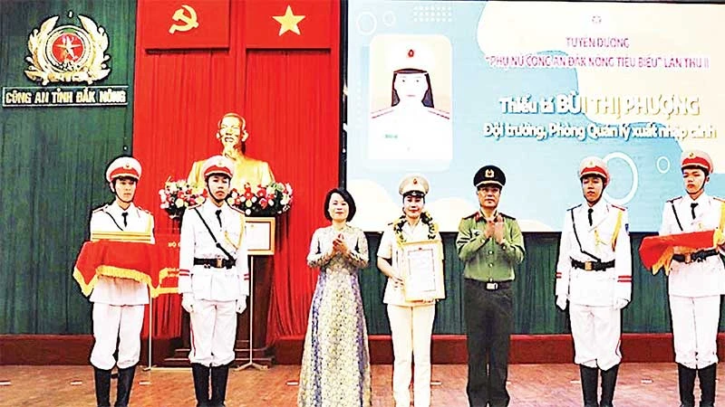 Thiếu tá Bùi Thị Phượng (đứng giữa) nhận Giải thưởng “Phụ nữ Công an Đắk Nông tiêu biểu lần thứ 2” do Giám đốc Công an tỉnh trao tặng.