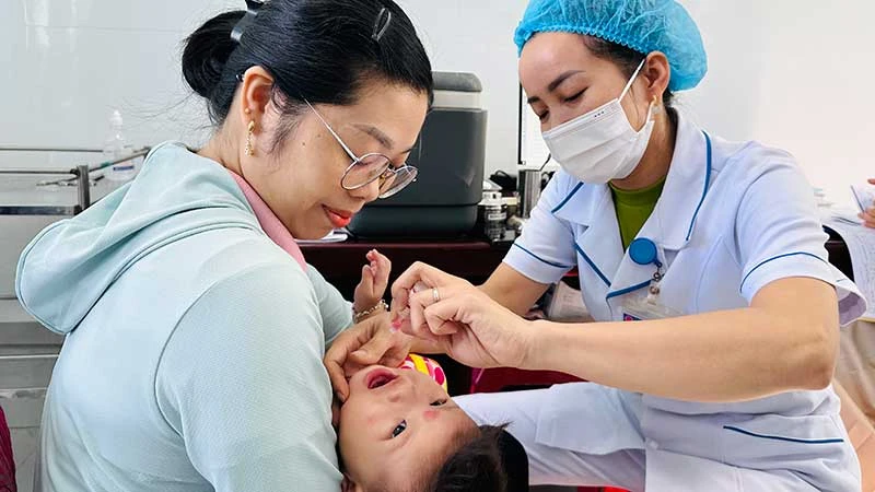 Nhờ được xây mới, đầu tư trang thiết bị, hoạt động chuyên môn của Trạm y tế xã Cam Tuyền (huyện Cam Lộ, tỉnh Quảng Trị) được nâng cao. Trong ảnh: Trẻ em uống vắc-xin phòng bại liệt tại trạm y tế.