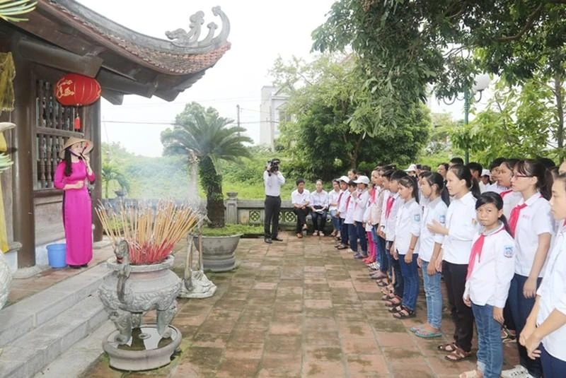 Các cháu học sinh nghe kể chuyện về tấm gương hy sinh của các Anh hùng liệt sĩ tại miếu thờ mười nữ dân quân Lam Hạ.