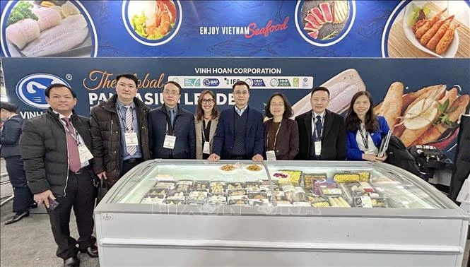 Đại diện Thương vụ Việt Nam tại Mexico hỗ trợ doanh nghiệp giới thiệu và quảng bá gian hàng của VINUT tại hội chợ. (Ảnh: TTXVN)