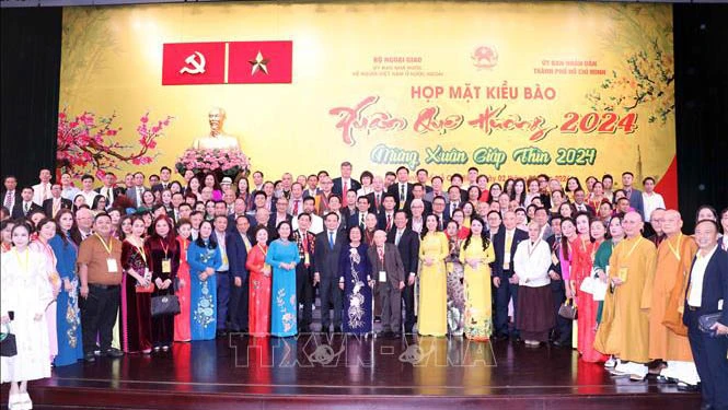 Phó Thủ tướng Trần Lưu Quang cùng lãnh đạo Thành phố Hồ Chí Minh chụp ảnh lưu niệm với các kiều bào. Ảnh: TTXVN