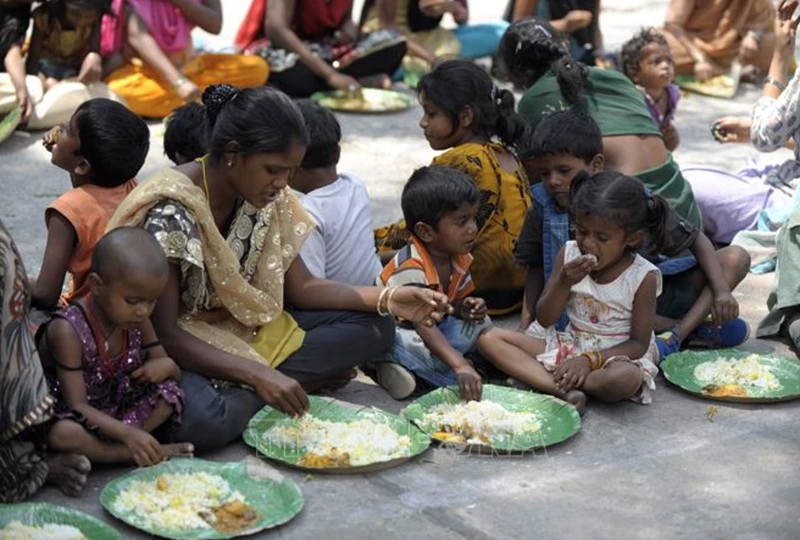 Ảnh minh họa: Người vô gia cư nhận thức ăn từ một chương trình cứu trợ dành cho người nghèo ở Hyderabad, Ấn Độ. Ảnh: AFP/TTXVN