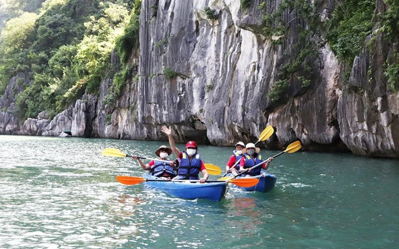 Khách du lịch quốc tế trong tour du lịch tham quan chèo thuyền kayak tại Vịnh Hạ Long. (Ảnh: NGHĨA HIẾU)