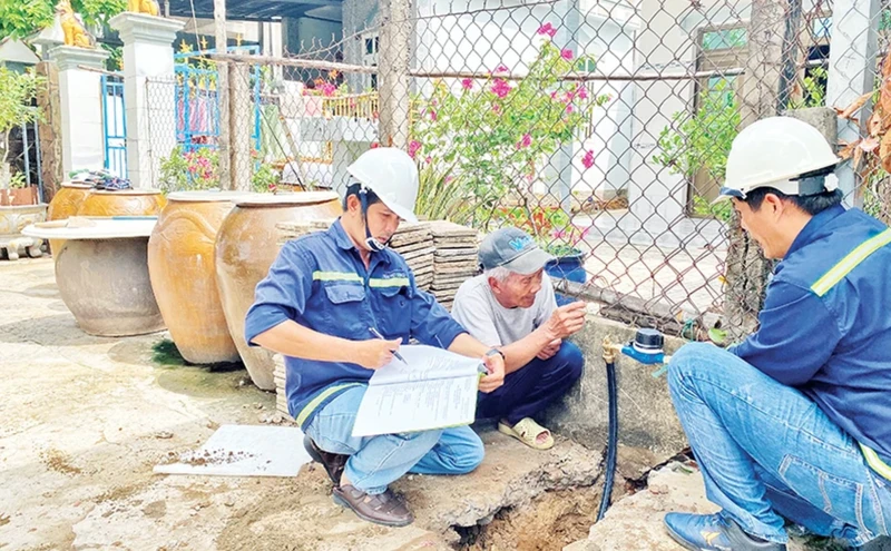 Nhân viên Xí nghiệp cấp nước Cần Giờ gắn đồng hồ nước thông minh thay cho đồng hồ cũ cho các hộ dân tại xã Tam Thôn Hiệp, huyện Cần Giờ.