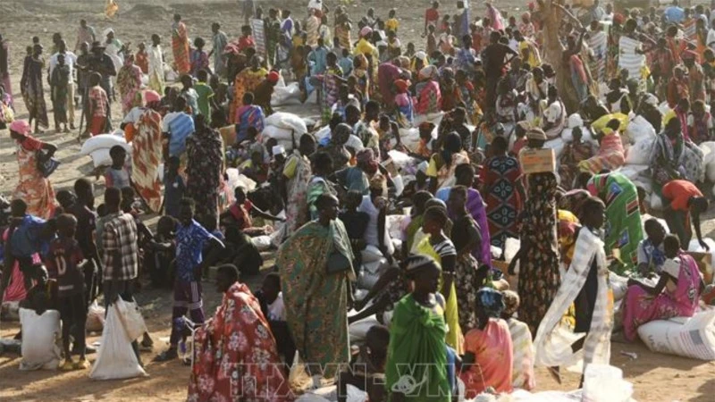 Người dân xếp hàng chờ nhận hàng cứu trợ tại Gedaref, Sudan. (Ảnh: AFP/TTXVN)