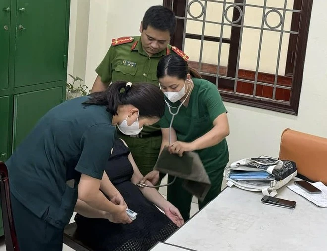 Cán bộ y tế phường Yên Phụ kiểm tra tình trạng sức khỏe và động viên tinh thần người phụ nữ.