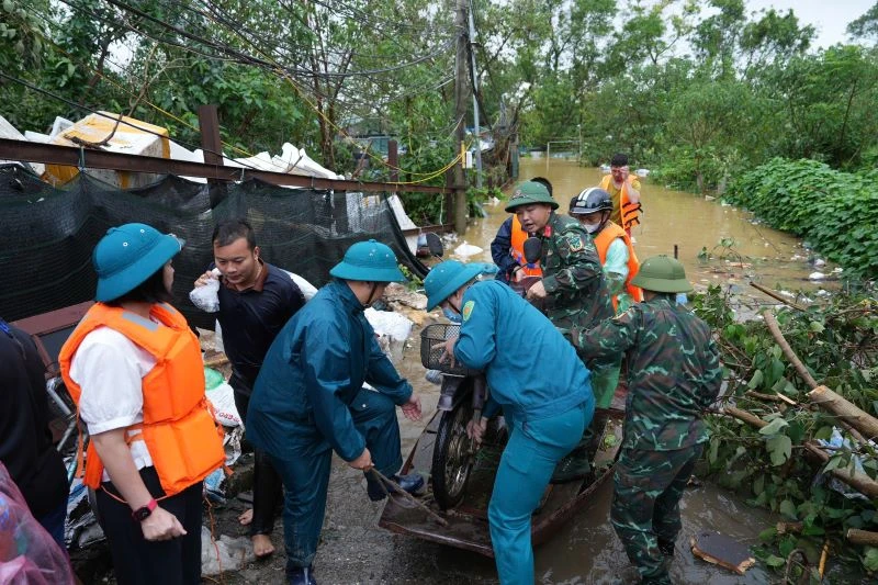 Các lực lượng chức năng quận Tây Hồ hỗ trợ các hộ dân ở bãi giữa sông Hồng sơ tán vào nơi an toàn.