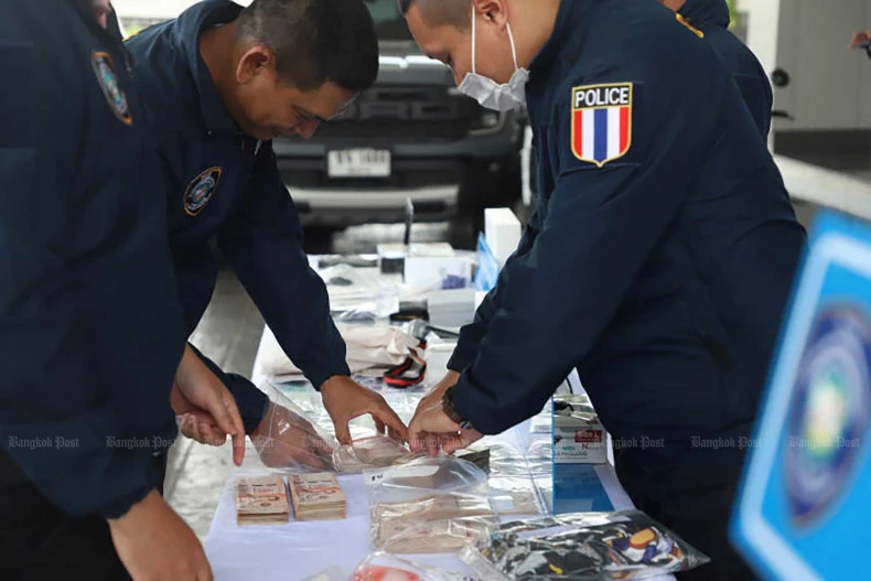 Các nhân viên CCIB xem xét chứng cứ thu được từ vụ bắt giữ băng nhóm lừa đảo kiểu trung tâm cuộc gọi hồi tháng 8. (Ảnh: Bưu điện Bangkok)