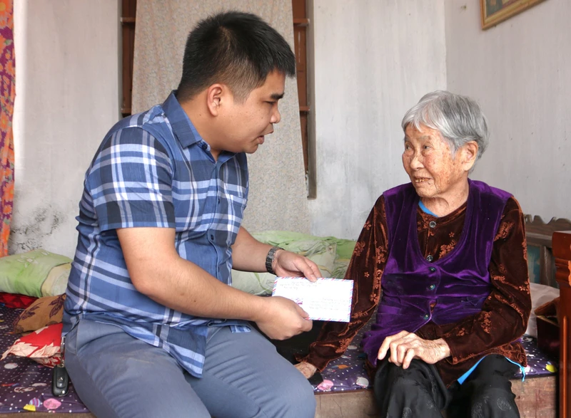 Đại diện Báo Lao động trao quà cho cụ Bùi Thị Mùi (93 tuổi), mẹ liệt sĩ Trần Văn Phòng (xã Minh Tân, huyện Kiến Xương, tỉnh Thái Bình).