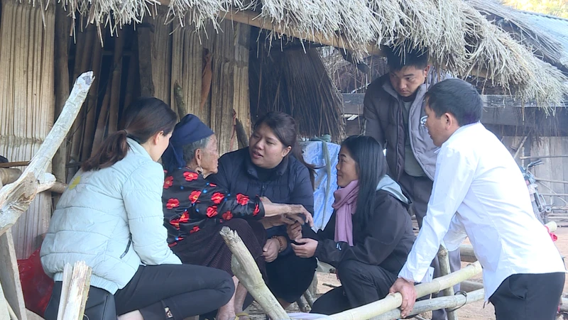 Thành viên tổ dân vận cơ sở huyện Nậm Pồ trao quà tết tặng bà Giàng Thị Dua ở bản mốc 4, xã Nậm Tin.