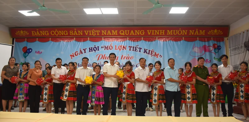 Các đồng chí lãnh đạo huyện Nậm Pồ và học sinh trong huyện hưởng ứng phong trào nuôi lợn đất ủng hộ cho giáo dục. 