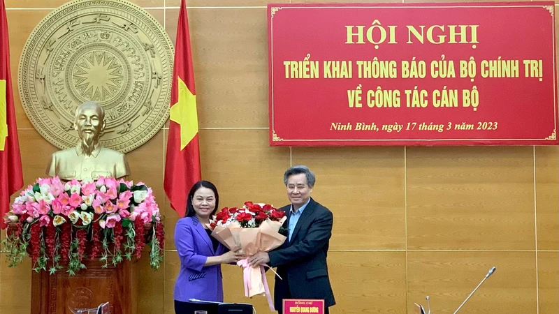 Đồng chí Nguyễn Quang Dương, Phó Trưởng Ban Tổ chức Trung ương tặng hoa chúc mừng đồng chí Nguyễn Thị Thu Hà. (Ảnh: YẾN TRINH)