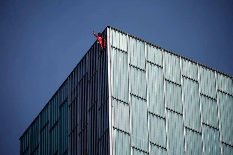 "Người nhện" Pháp Alain Robert trèo lên một tòa nhà ở Barcelona, ​​Tây Ban Nha vào ngày 5/5 để nâng cao nhận thức về hạn hán và biến đổi khí hậu. Ảnh: Reuters.